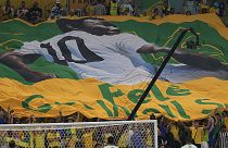 Football fans hold a giant Brazilian flag with a picture of Brazilian football legend Pele with a message "Pele, Get well soon" in Qatar, 2 December 2022