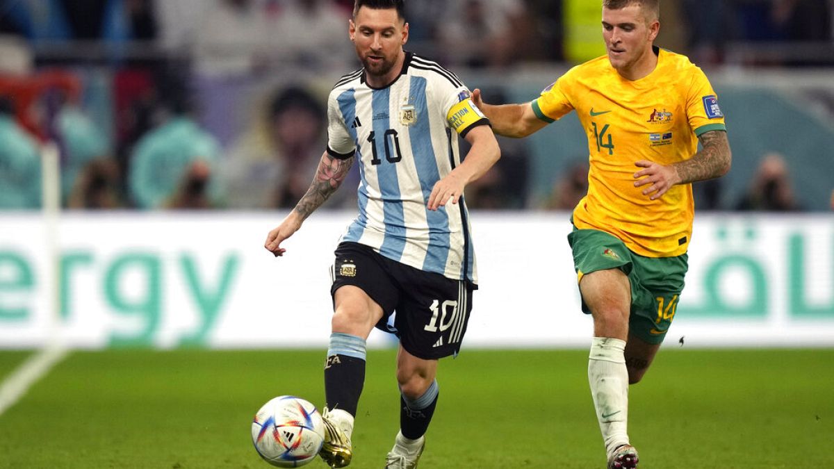 Argentina's Lionel Messi and Australia's Riley McGree fight for the ball during the World Cup round of 16 match between Argentina and Australia.