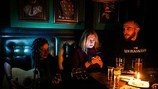 Un concert à la lueur d'une bougie, dans un bar de Lviv, plongé dans le noir, le 2 décembre 2022, Ukraine
