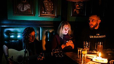 Un concert à la lueur d'une bougie, dans un bar de Lviv, plongé dans le noir, le 2 décembre 2022, Ukraine