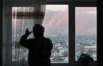 A local resident opens the curtains on a window with a view of the Gazprom Neft's oil refinery in Omsk, Russia November 18, 2022.