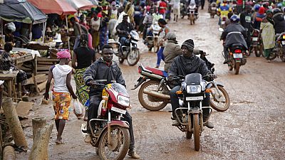 In this Aug. 8, 2015 photo, drivers ride motorbike taxis in the market in Kenema, eastern Sierra Leone
