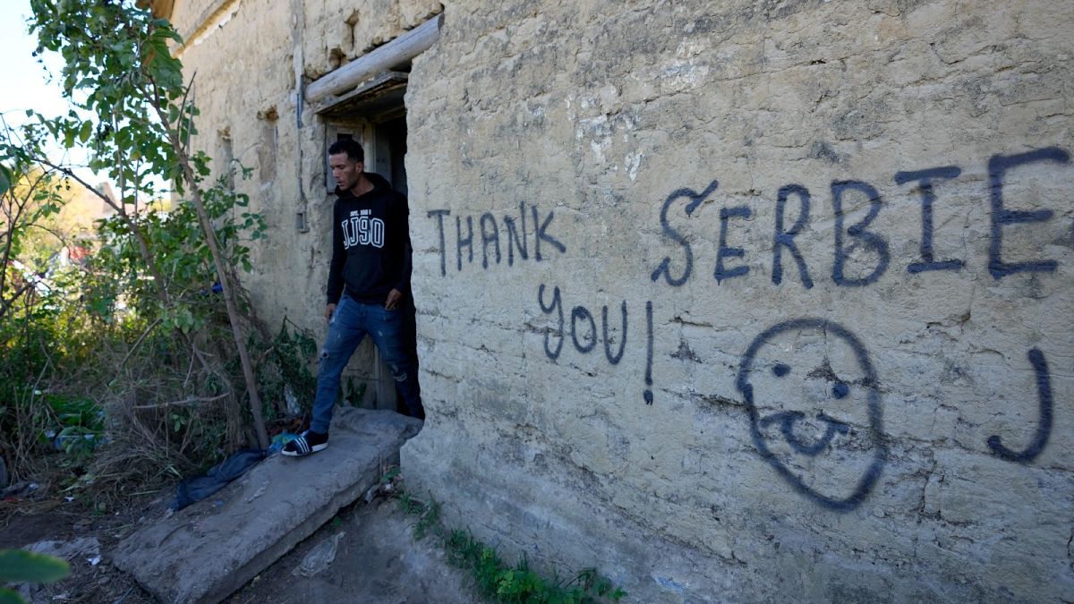 A migrant leaves an abandoned house at a makeshift camp near a border line between Serbia and Hungary, near village of Horgos, Serbia, Oct. 20, 2022.