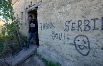 A migrant leaves an abandoned house at a makeshift camp near a border line between Serbia and Hungary, near village of Horgos, Serbia, Oct. 20, 2022.