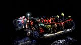 مهاجرون يجلسون على زورق مطاطي أثناء عملية الإنقاذ التي نفذتها طواقم السفينتين "هيومانيتي 1" و"لويس ميشال"  في المياه الدولية قبالة السواحل الليبية، الأحد 4 ديسمبر/كانون الأول