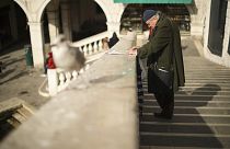 A local reads a newspaper at the Rialto bridge in Venice. Saturday, 29 February 2020.