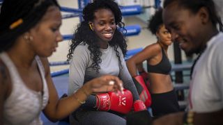 La boxeadora Legnis Cala, en el centro, habla con otras boxeadoras durante una sesión de entrenamiento en La Habana, Cuba.