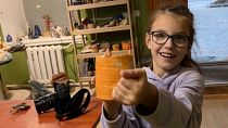 Una niña muestra la taza que ha hecho en el taller de cerámica de Mikolaiv