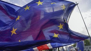 Una bandera de la Unión ondea detrás de una bandera de la Unión Europea, frente a las Casas del Parlamento, en Londres, el miércoles 19 de octubre de 2022.