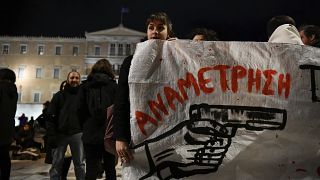 متظاهرون أمام يحملون لافتة كتب عليها باللغة اليونانية "مواجهة" أثناء احتجاجهم على إطلاق النار على  شاب يبلغ من العمر 16 عامًا