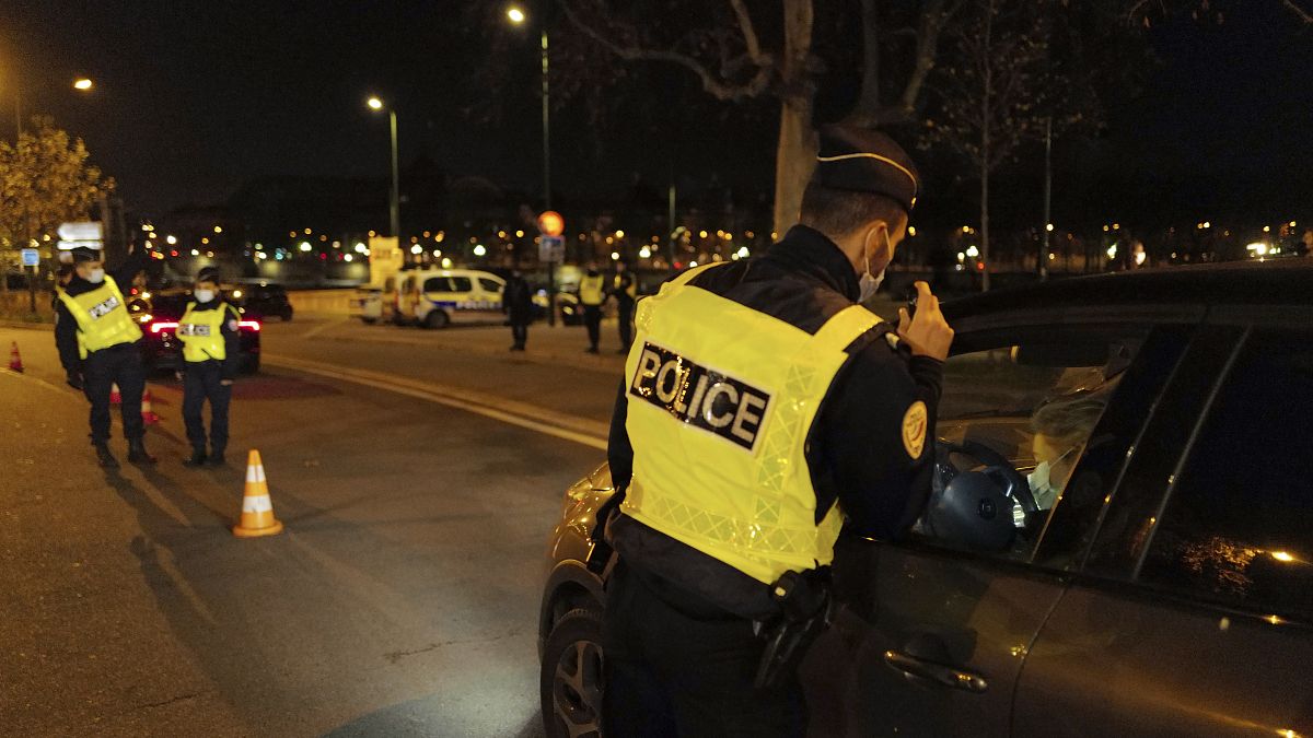 French police officers control a car near the National Assembly, as they enforce a curfew, in Paris, France, Tuesday Dec. 15, 2020.