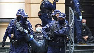 Police remove one of several protesters who had blocked the entrance of the country's constitutional court in an act of civil disobedience in Warsaw, Poland, on Aug. 30, 2022.