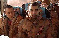 A group of Russian soldiers sit in a bus after being released in bilateral prisoner swap