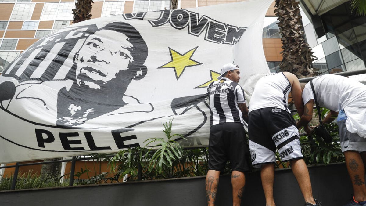  مشجعو فريق سانتوس لكرة القدم يضعون لافتة عليها صورة نجم كرة القدم السابق بيليه، أمام مستشفى ألبرت أينشتاين في ساو باولو، البرازيل، 4 نوفمبر 2022.