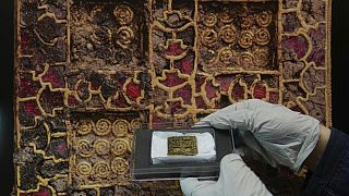 Liz Barham, senior conservator of the Museum of London Archaeology, displays an early medieval gold and gemstone necklace during a photo call, in London, Tuesday, Dec. 6, 2022