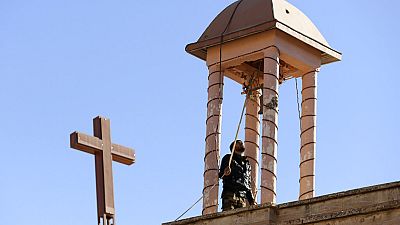 Un combattant kurde irakien fait sonner la cloche d'une église, endommagée par Daesh pendant leur occupation de Bashiqa, à l'est de Mossoul, en Irak, mercredi 7 décembre 2016.