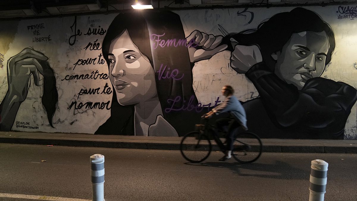 صورة جدارية في شارع بباريس لنساء إيرانيات يخلعن الحجاب ويقصن شعرهن