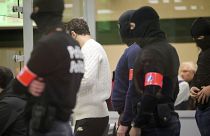 عناصر من الشرطة الخاصة خلف المتهمين قبل بدء محاكمة المتهمين في تفجيرات مترو ومطار بروكسل في 22 مارس 2016.
