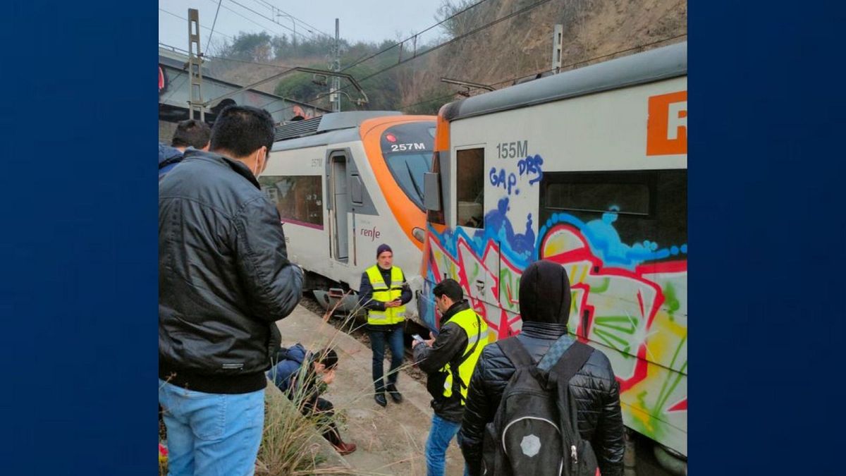 Passengers and railway staff are seen at the scene of a train collision in Montcada i Reixac, Spain, Wednesday Dec. 7, 2022