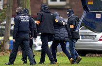 Un suspect escorté par des policiers à son arrivée au bureau du procureur fédéral à Karlsruhe, en Allemagne, mercredi 7 décembre 2022. 