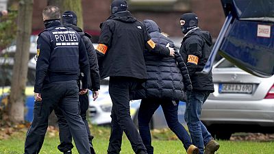 Un suspect escorté par des policiers à son arrivée au bureau du procureur fédéral à Karlsruhe, en Allemagne, mercredi 7 décembre 2022. 