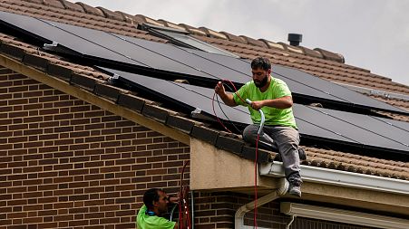 Workers install solar planers on the roof of a house in Rivas Vaciamadrid, Spain.
