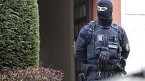 Police officers stand by a searched property in Frankfurt during a raid against so-called 'Reich citizens' in Frankfurt, Germany, Wednesday, Dec. 7, 2022.