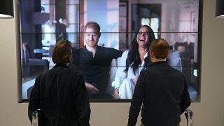 Des employés de bureau à Londres regardant un extrait du documentaire "Harry & Meghan", le 8 décembre 2022