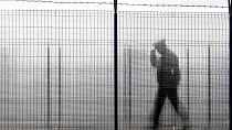 ضابط شرطة الحدود الروماني ، شوهد من خلال سياج زجاجي، يقوم بدوريات في نقطة عبور حدودية بين رومانيا ومولدوفا في رومانيا. 2011/01/10