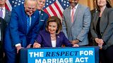 House Speaker Nancy Pelosi signs the Respect For Marriage Act with other members of Congress. 