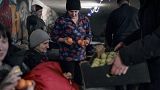 Policeman Chaplain Leonid presents people with tangerines and apples before Christmas in a basement used as a bomb shelter in Avdiivka, Donetsk region, December 8, 2022.