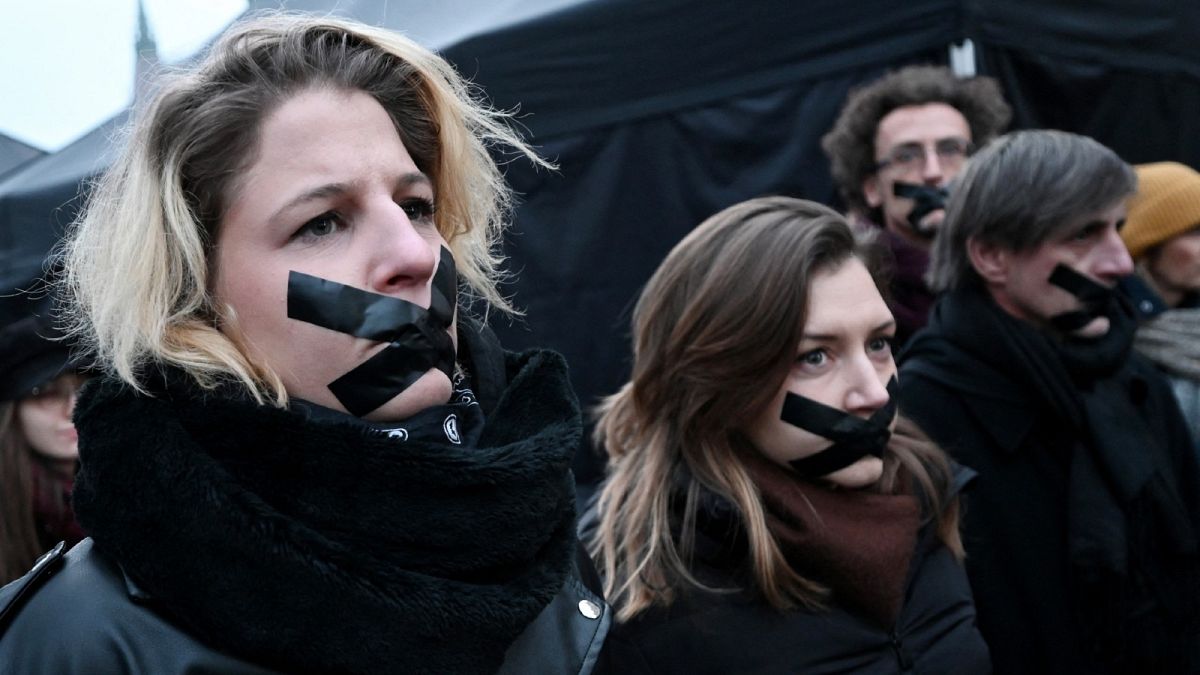 Participants stand with tape over their mouths during a demonstration of teachers, students and parents in Budapest