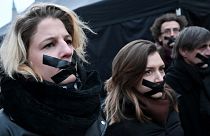 Participants stand with tape over their mouths during a demonstration of teachers, students and parents in Budapest