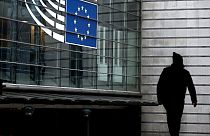 A man walks near the entrance of the European Parliament in Brussels on December 9, 2022.