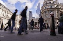 People walk outside the Bank of England, in the financial district known as The City, in London, Friday, Oct. 7, 2022.