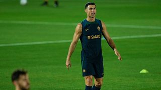 Portugal's Cristiano Ronaldo stands at the pitch with teammates during his team training session at the World Cup in Doha.