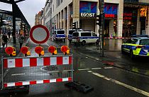 Police vehicles are parked around a cordoned off area at the Altmarktgalerie after a hostage situation in Dresden, Germany, Saturday Dec. 10, 2022. 
