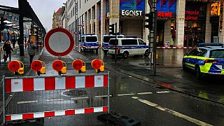 Police vehicles are parked around a cordoned off area at the Altmarktgalerie after a hostage situation in Dresden, Germany, Saturday Dec. 10, 2022. 