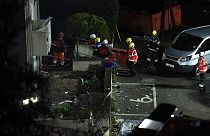 Fire crews mobilised work in the rubble of a low-rise apartment block after an explosion on December 10, 2022.