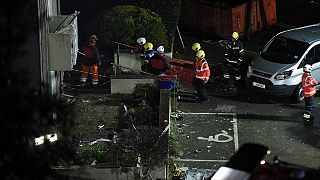 Fire crews mobilised work in the rubble of a low-rise apartment block after an explosion on December 10, 2022.