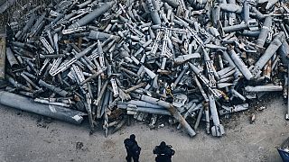 Des policiers regardent des fragments collectés des roquettes russes qui ont frappé Kharkiv, à Kharkiv, en Ukraine, samedi 3 décembre 2022.