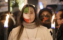 Une manifestante avec un drapeau iranien peint sur le visage participe à une procession en l'honneur des lauréats du prix Nobel de la paix à Oslo, 10/12/2022