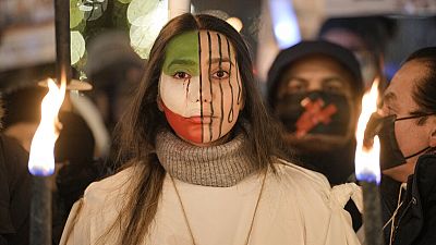 Une manifestante avec un drapeau iranien peint sur le visage participe à une procession en l'honneur des lauréats du prix Nobel de la paix à Oslo, 10/12/2022