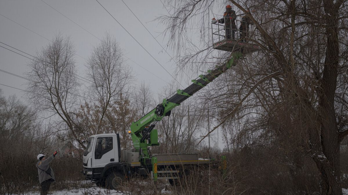 Workers from Ukraine's DTEK company maintain power lines in Kyiv on Thursday, December 8, 2022.