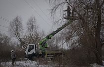 Des travailleurs de la société DTEK entretiennent les lignes électriques à Kyiv en Ukraine, jeudi 8 décembre 2022. 
