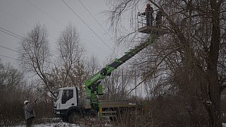 Workers from Ukraine's DTEK company maintain power lines in Kyiv on Thursday, December 8, 2022.