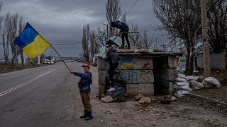 Ukrainian children play at an abandoned checkpoint in Kherson, southern Ukraine, Wednesday, Nov. 23, 2022.