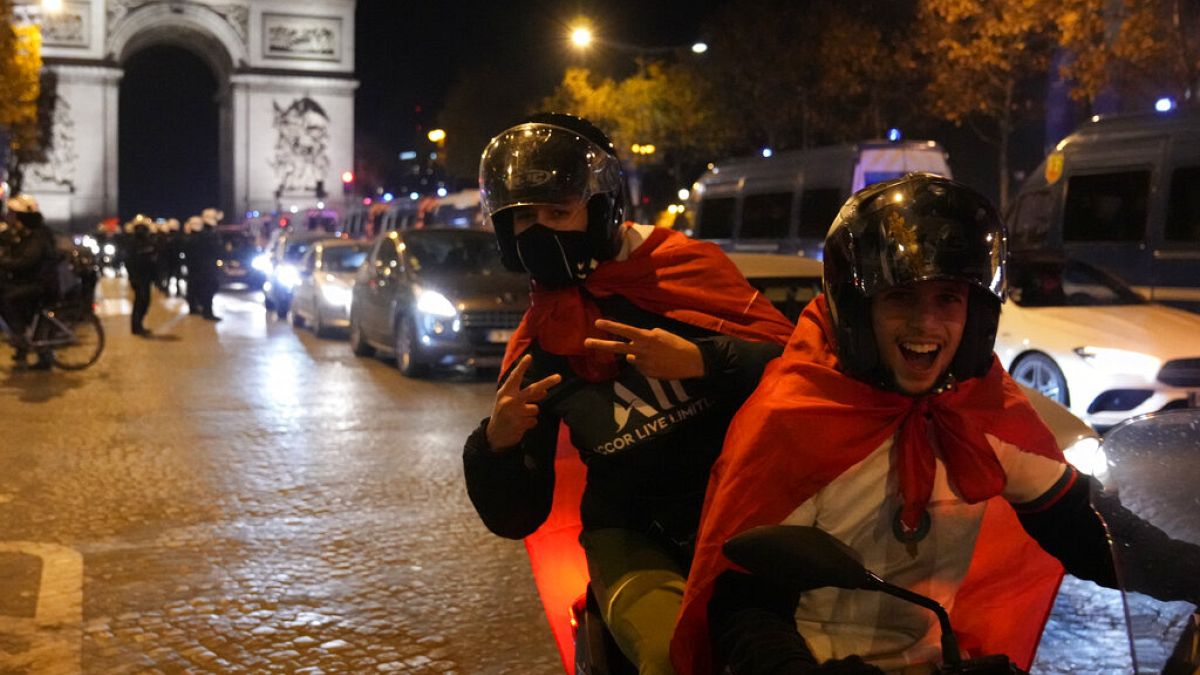 Morocco football fans celebrate their team's victory over Portugal on the Champs-Elysees in Paris. 