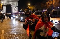 Morocco football fans celebrate their team's victory over Portugal on the Champs-Elysees in Paris.