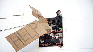 Plastic slippers are given to a man disembarking from the Geo Barents rescue ship in Italy.